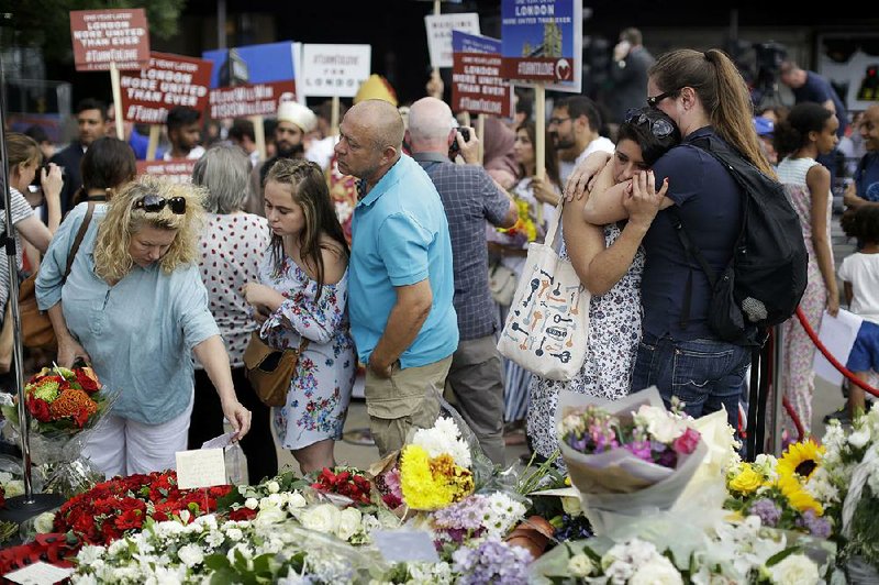 People view a memorial Sunday on London Bridge after a minute of silence marking the anniversary of an attack by three Islamic State-inspired extremists. Eight people died on June 3, 2017, when the attackers used a van to ram pedestrians, then left the vehicle and stabbed people at nearby bars and restaurants. 