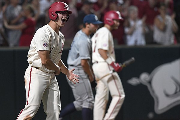 Arkansas first baseman Jared Gates (3) celebrates after scoring a run during an NCAA Tournament game against Dallas Baptist on Sunday, June 3, 2018, in Fayetteville. 