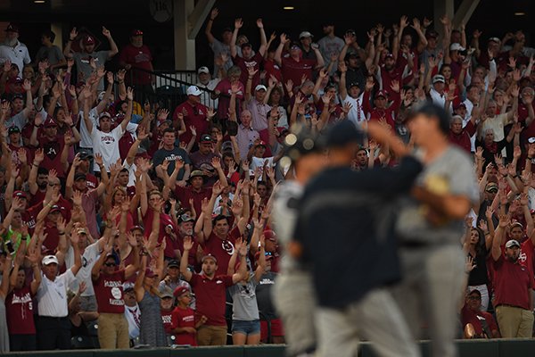 Arkansas fans call the Hogs while members of Dallas Baptist visit on the mound during an NCAA Tournament game Sunday, June 3, 2018, in Fayetteville. 