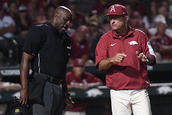 Arkansas head coach Dave Van Horn, right, talks with home plate umpire Linus Baker during an NCAA Tournament game against Dallas Baptist on Sunday, June 3, 2018, in Fayetteville. 