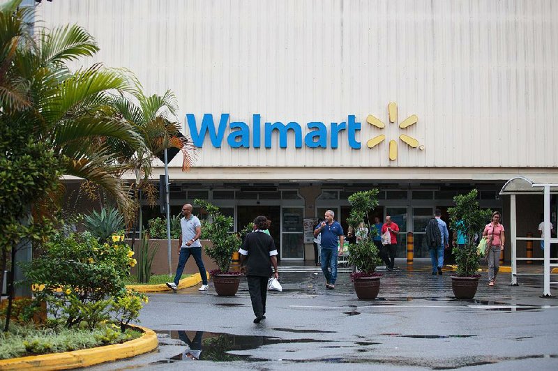Customers walk outside a Walmart store in Sao Paulo, Brazil, in this 2016 file photo. Walmart said Monday that a private equity investment firm was buying a majority stake in Walmart Brazil.