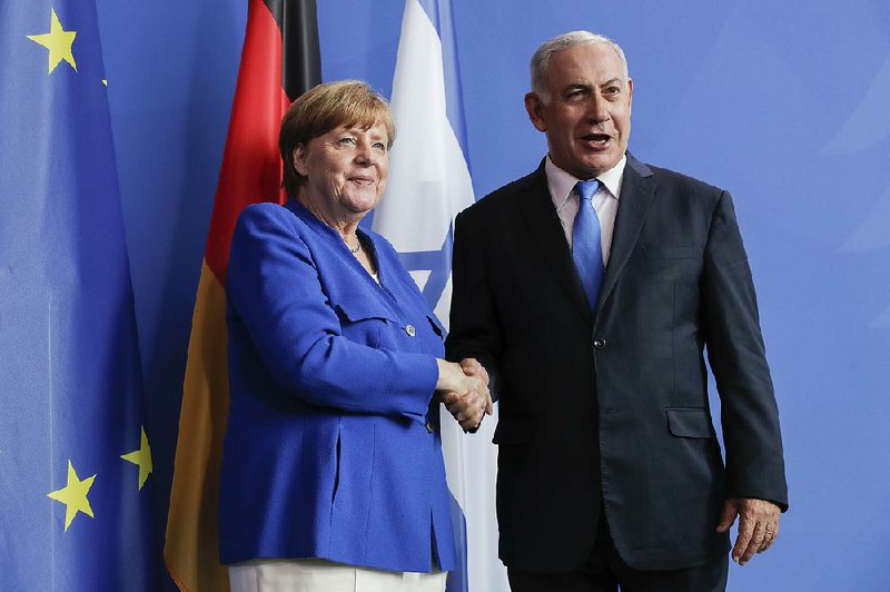 German Chancellor Angela Merkel and Israeli Prime Minister Benjamin Netanyahu shake hands Monday after a meeting at the chancellery in Berlin.   