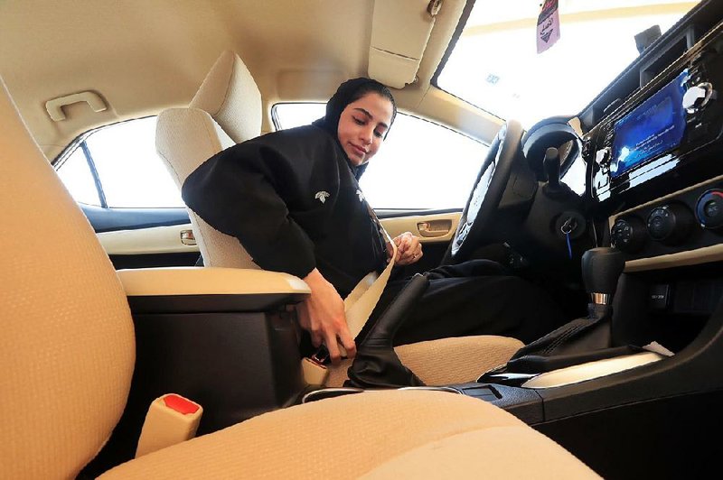 This image released by the Saudi Information Ministry shows a Saudi woman buckling her seat belt Monday before doing a driving test at the General Department of Traffic in the Saudi capital, Riyadh.  
