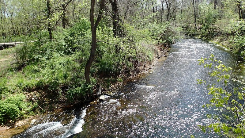 Spring Creek is seen from a bridge on a spur trail off the Razorback Greenway at a trailhead on Silent Grove Road.