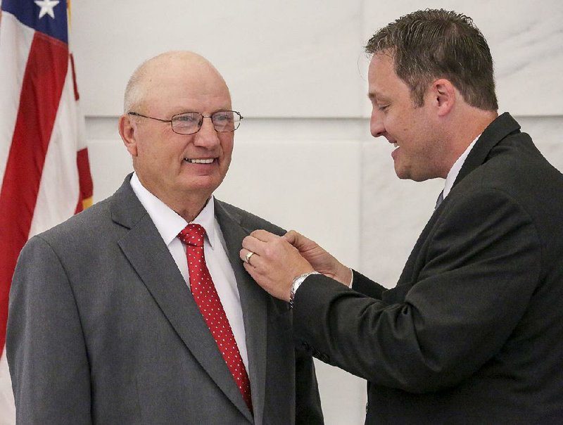 Donald Ragland of Marshall (left), and Speaker of the Arkansas House Jeremy Gillam of Judsonia chuckle as Gillam struggles with a House lapel pin. Ragland was sworn in as representative for House District 83 during a ceremony in the state Capitol rotunda Tuesday morning in Little Rock.  