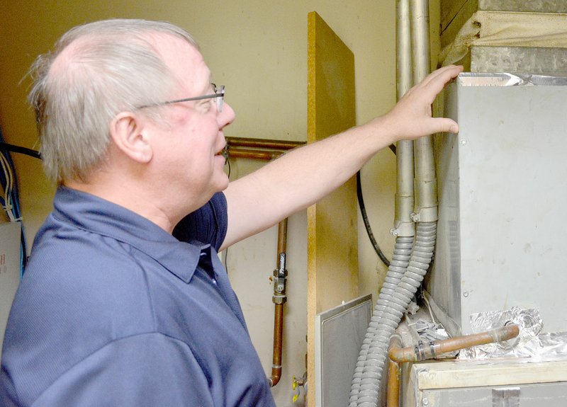 Keith Bryant/The Weekly Vista Doug Fisher takes a look at an HVAC unit.