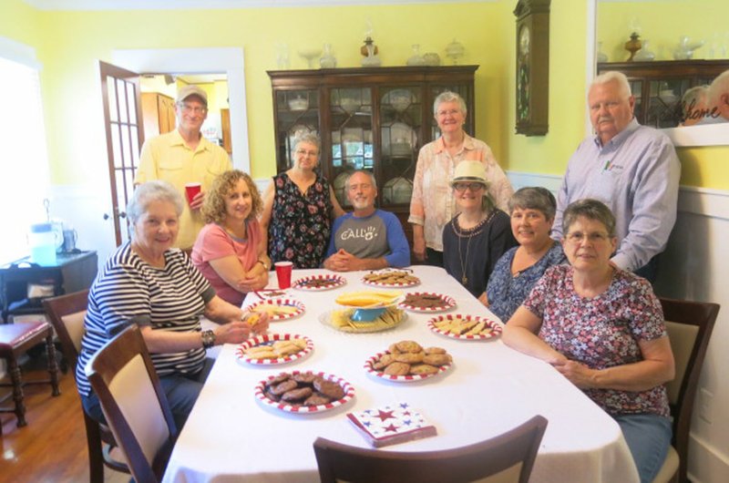 Westside Eagle Observer/SUSAN HOLLAND Marcy and Harris Steele, at the head of the table, pause for a photo with some of their guests at an open house May 26 at A Place to Call Home, the foster home they have recently opened for young men. Anna Lee Janisch, who lived in the historic home almost 40 years when her husband was pastor of Shiloh Church, stands at Harris' left.