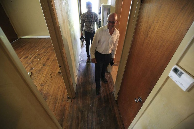 Charles Levesque, with Depaul USA, leads the way Wednesday as he and Bryan Griffith, with the mayor’s office, check out the house being renovated at 6601 Heather Lane in Little Rock. 