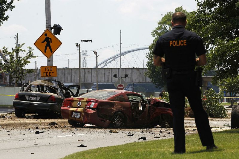 North Little Rock officer Andrew Miles uses a drone to record the scene of a two-vehicle crash Wednesday on Riverfront Drive. Four people were taken to hospitals with “significant and life-threatening” injuries. One, a 12-year-old girl, later died. 