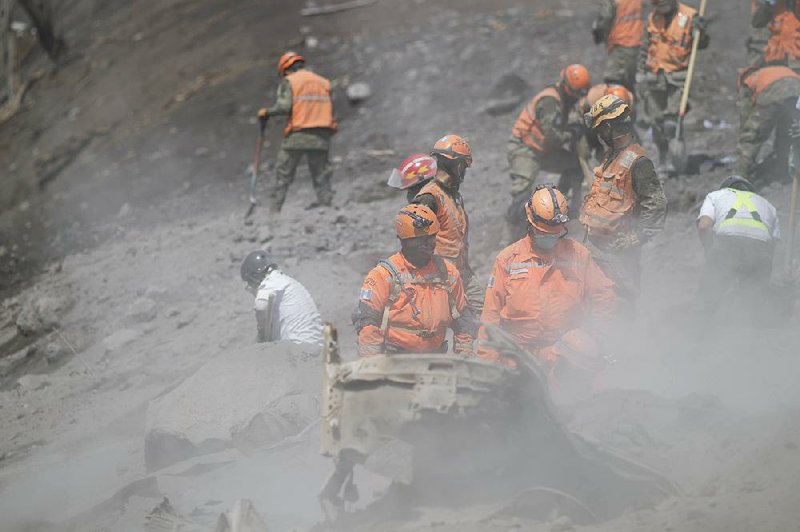 Firefighters in El Rodeo, Guatemala, assess the stability Wednesday of an area where a bridge had stood before Sunday’s eruption of the Volcano of Fire.  