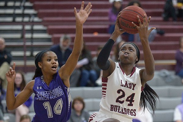 Marquesha Davis (24) of Springdale reaches to score as Coriah Beck of Fayetteville defends Tuesday, Feb. 20, 2018, during the first half in Bulldog Gymnasium in Springdale.