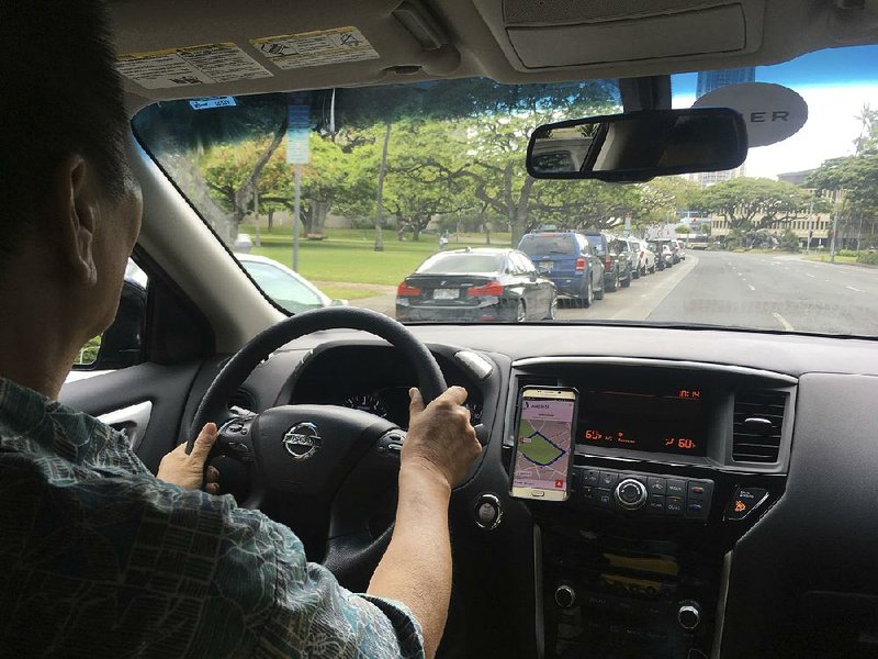 Joshua Oh drives for Uber on Wednesday in Honolulu, where the City Council has decided to prevent ride-hailing services from “surge pricing.”  