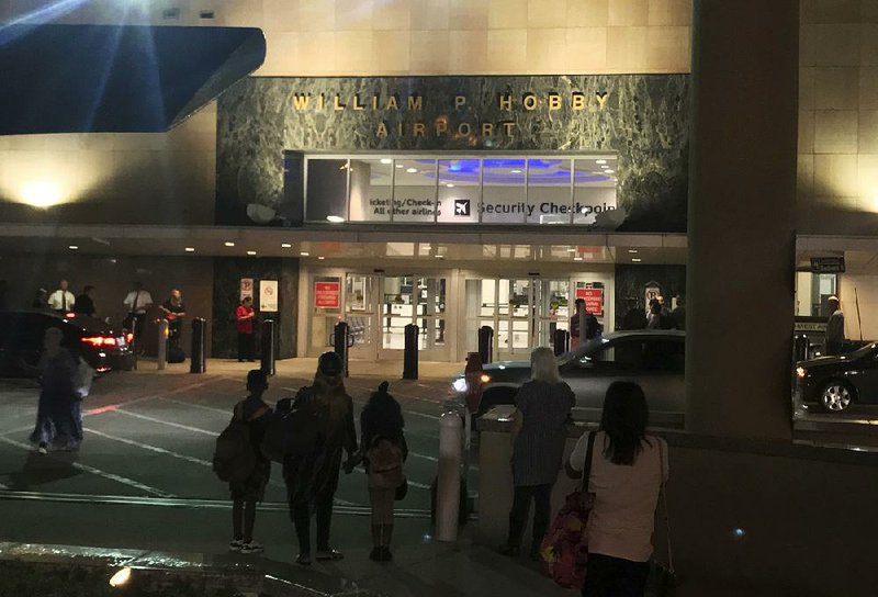 People wait early Thursday outside Houston’s William P. Hobby Airport after a toy grenade in a passenger’s bag closed a security checkpoint.   
