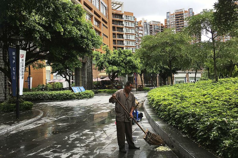 A man works Thursday near the high-rise apartment buildings where U.S. government workers have reported unexplained health problems in Guangzhou, China.  