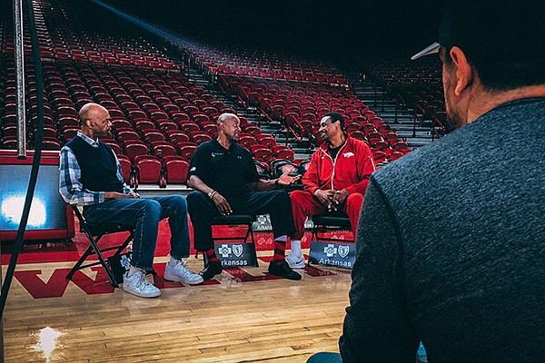 From left to right, former Arkansas basketball players Ron Brewer, Sidney Moncrief and Marvin Delph speak while filmmaker Christopher Hunt, foreground, watches on Wednesday, Feb. 28, 2018, at Bud Walton Arena in Fayetteville. The "Triplets," as the trio is known, were interviewed for a documentary film about their former coach, Eddie Sutton.