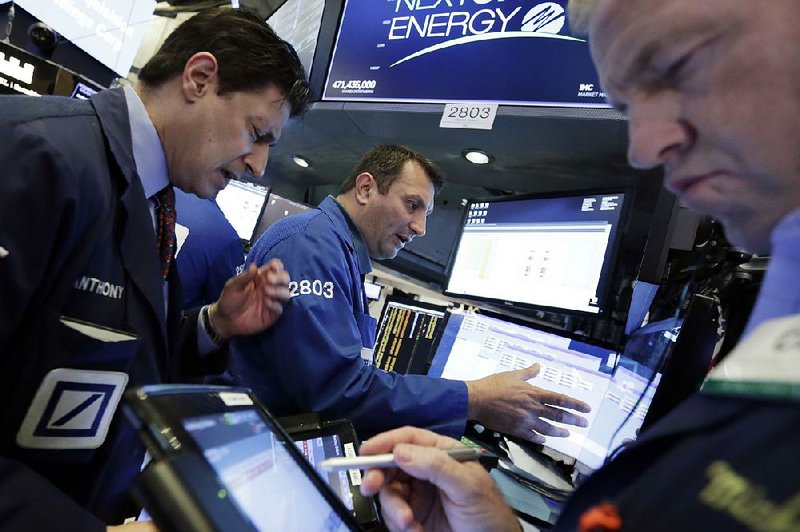 Specialist Vincent Surace (center) works with traders Anthony Carannante (left) and Michael Smyth on the floor of the New York Stock Exchange on Friday.  