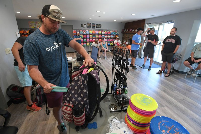 NWA Democrat-Gazette/J.T. WAMPLER Matt Loyd packs his bag for the Tuesday night mini tournament as players gather in the pro shop, Dynamic Discs of Northwest Arkansas, Tuesday June 5, 2018 at J. Beast Disc Golf Course at J.B. Hunt Park in Springdale.