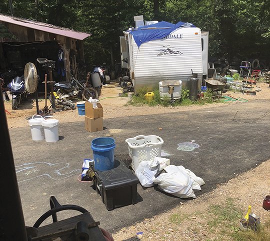 Submitted photo METH LAB: Components to an active meth lab are seen near a camper at 124 Curtis Lane Friday morning after multiple law enforcement agencies raided the property. The suspect being sought, Rodney Blocker, 43, eluded capture, but felony warrants are being issued for his arrest.