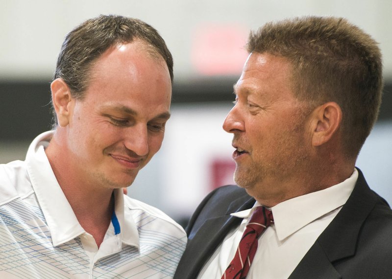 Scotty Price (left) is hugged Friday by Tom Smith during Benton County’s Drug Court and Veterans Treatment Court graduation at the Church of Christ in Bentonville.