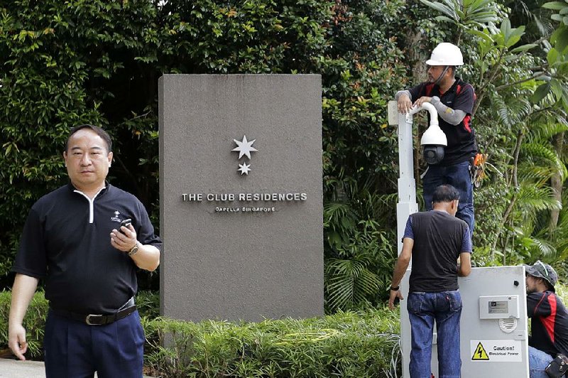 Technicians install a surveillance camera Saturday at the entrance of the Capella Hotel on Sentosa Island in Singapore as part of security measures for this week’s U.S.-North Korea summit.  