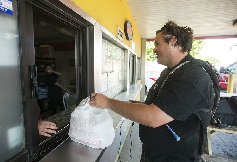 Eddie Bouchez, a driver for the food-delivery company Waitr, picks up an order Wednesday at Mangos Gourmet Taco Shop in Fayetteville.  