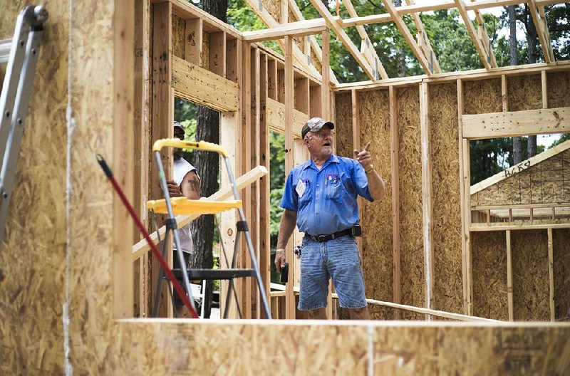 Dennis Kronberg of Wausa, Neb. (center) installs refrigeration lines for air conditioning, Friday, June 8, 2018 on Passion Play Road, across the street from the Washington Regional clinic in Eureka Springs.  Eight tiny houses are being built in Eureka Springs, which has a dearth of affordable housing. They're being constructed by 66 volunteers from 13 states with World Mission Builders. 