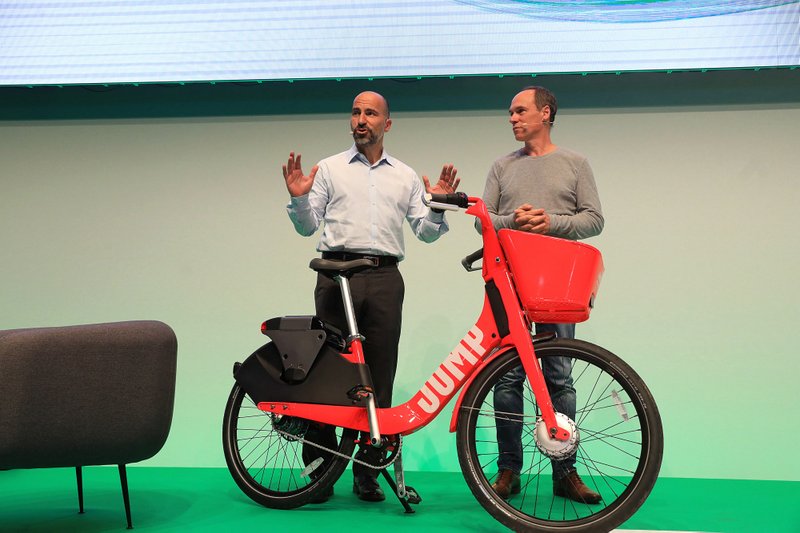 Dara Khosrowshahi, chief executive officer of Uber, left, presents a JUMP ride sharing hire-bicycle in Berlin, Germany, on June 6, 2018.