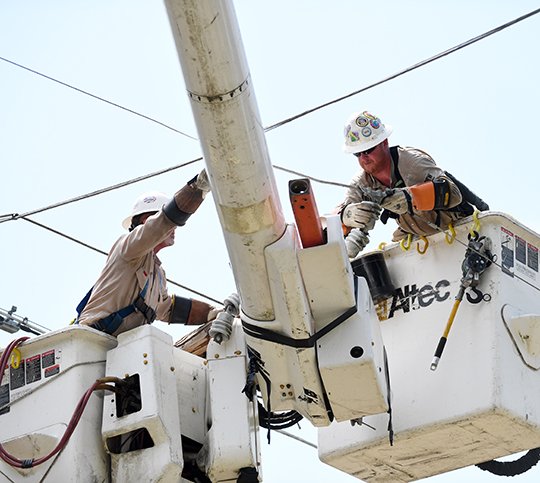 The Sentinel-Record/Grace Brown- Workers with BBC Electric out of Joplin, Mo., work on removing park of a broken utility pole and restore power to rearby residents in the 200 block of True Grit Lane on Saturday, June 9, 2018.