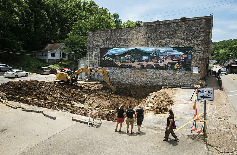 The hole from a collapsed tunnel under a Main Street parking lot in Eureka Springs measured about 70-by-50 feet and 25-30 feet deep by Friday. 