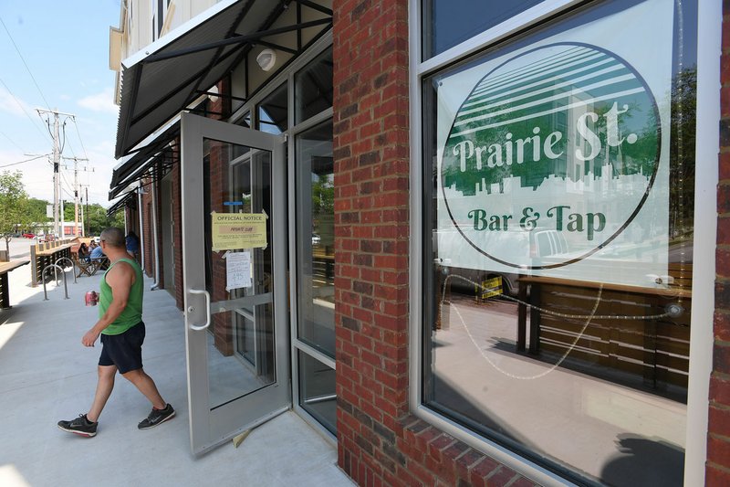 NWA Democrat-Gazette/J.T. WAMPLER Dan Daniel takes a break from painting Thursday at Prairie St. Bar & Tap in Fayetteville. The new watering hole, opening later this summer, will be a private club. A state law enacted last year requires municipalities to approve private club applications before the state reviews them. The Fayetteville City Council approved the business' private club application in April. Daniel is the general manager at the club.