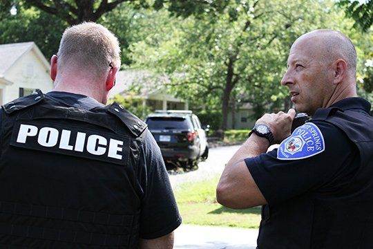 The 200 block of Vineyard St. was cordoned off for more than seven hours Sunday as Hot Springs Police tried to negotiate a peaceful end to a standoff. Jonathan Burfeind (left), supervisor of voilent crimes and Lieutenant Larry Patrick look on at the residence. Lt. Patrick said about five units responded to a welfare check call around 10 a.m. Police Chief Jason Stachey said, &quot;We want to peacefully resolve the situation and get the gentlemen inside some help. We are working under belief that there is possible weapons inside the residence, that's why we are taking such precautions for the individual and our officers.&quot; (The Sentinel-Record/Rebekah Hedges) 