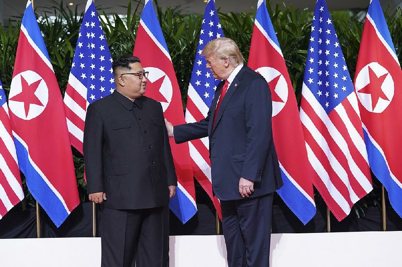 President Donald Trump and Kim Jong Un of North Korea greet each other today before their meeting on Sentosa Island in Singapore.  