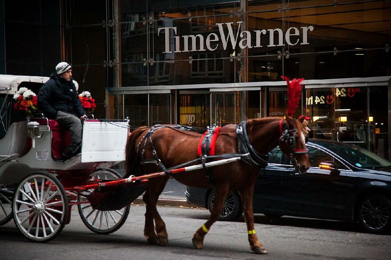 A horse-drawn carriage passes the Time Warner Inc. center in New York in this 2016 file photo. A ruling is expected today in the government’s antitrust lawsuit to block AT&T’s proposed $85.4 billion acquisition of Time Warner.  