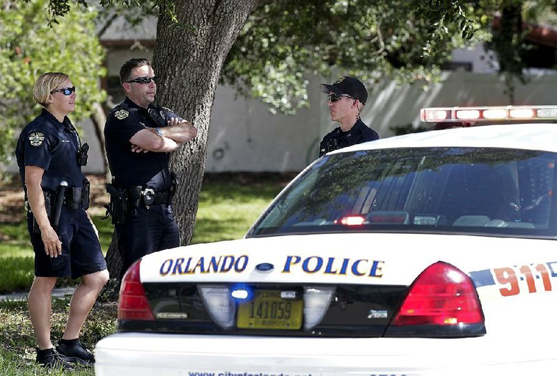 Orlando police block an intersection leading to an apartment complex where an officer was shot and seriously wounded Monday before the gunman barricaded himself in an apartment with young children. 