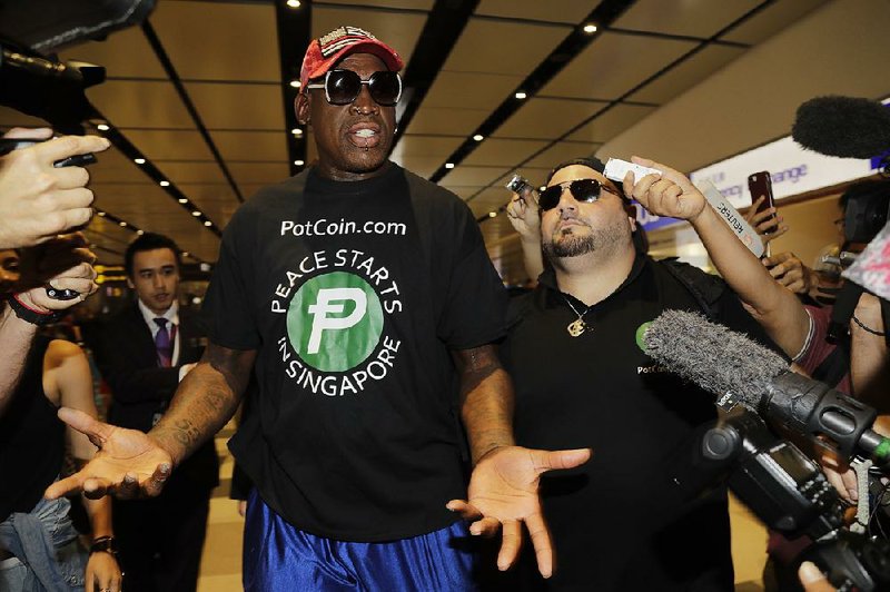 Former NBA basketball player Dennis Rodman and Chris Volo (right) arrive at Singapore's airport on Tuesday.
