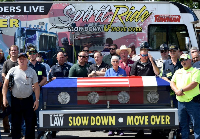 Westside Eagle Observer/MIKE ECKELS Several members of the Northwest Arkansas tow operator community, along with law enforcement and emergency personnel, gather in front of the "Spirit" casket June 8 at Tontitown City Park. "Spirit" is part of the Spirit Ride campaign to raise awareness for the Move Over law which requires motorists to slow down and move over when emergency and tow vehicles are present along the highway.