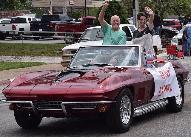 Westside Eagle Observer/MIKE ECKELS Bill Montgomery (left) and wife Michel greet family and friends as they lead the Decatur Barbecue parade through downtown Decatur August 5, 2017. The parade will return to downtown Decatur August 4 during the 65th Annual Decatur Barbecue. The theme for this year's event is "Then and Now," the history of the Decatur Barbecue.