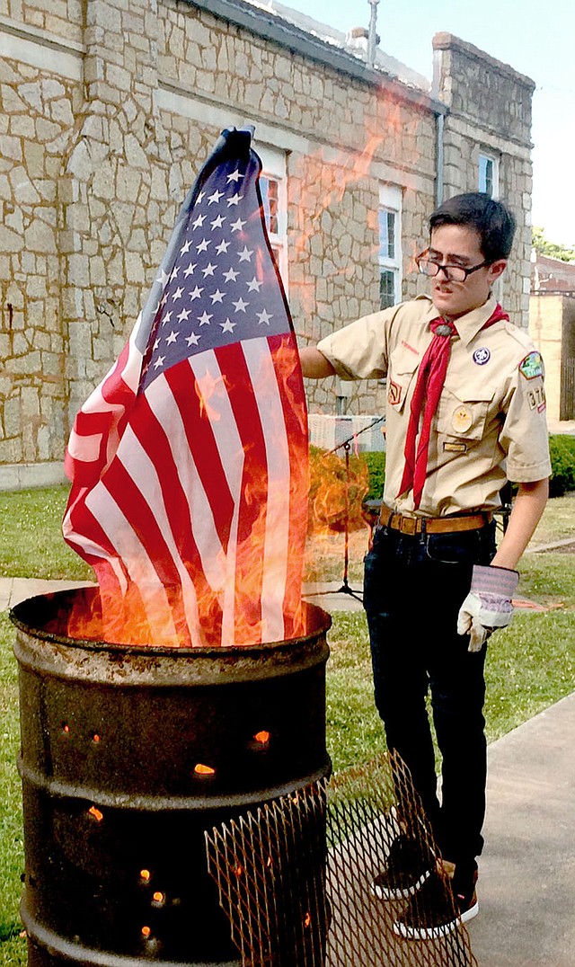 Janelle Jessen/Herald-Leader Avrey Della Rosa, a member of Boy Scout Troop 3766, retired a U.S. flag during a flag retirement ceremony on Saturday evening. The event was conducted by American Legion Post 29, the Sons of the American Legion and the Boy Scout Troop.