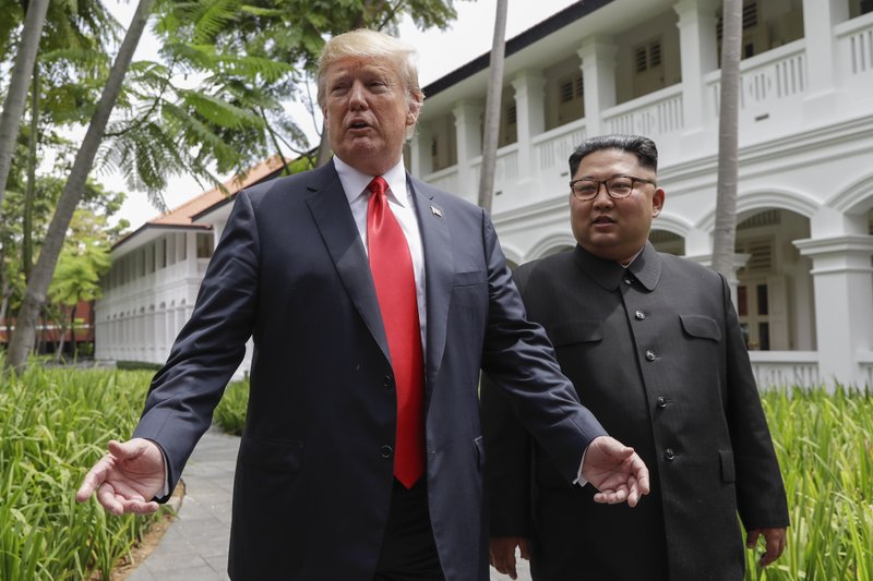 U.S. President Donald Trump and North Korea leader Kim Jong Un stop to talk with the media as they walk from their lunch at the Capella resort on Sentosa Island Tuesday, June 12, 2018 in Singapore. (AP Photo/Evan Vucci)