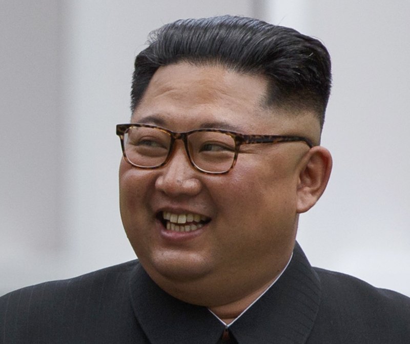 North Korean leader Kim Jong Un smiles while walking with U.S. President Donald Trump on Sentosa Island in Singapore Tuesday, June 12, 2018. Kim has a sweptback hairstyle with the sides and back shaved neatly, and experts say it's part of his efforts to model his appearance on his grandfather Kim Il Sung who founded North Korea in 1948. (AP Photo/Evan Vucci)