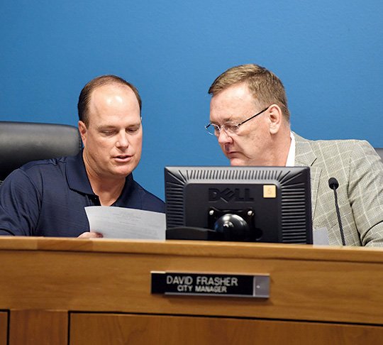 The Sentinel-Record/Grace Brown RESIGNATION TENDERED: Assistant City Manger/City Clerk Lance Spicer, left, speaks with City Manager David Frasher Tuesday at City Hall. The board later convened an executive session and accepted Frasher's resignation.
