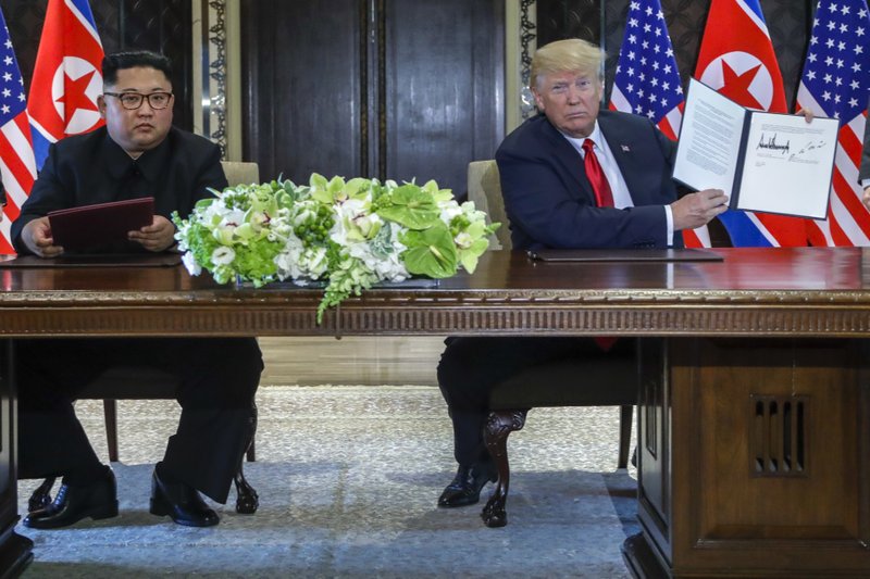 U.S. President Donald Trump holds up the document that he and North Korea leader Kim Jong Un just signed at the Capella resort on Sentosa Island Tuesday, June 12, 2018 in Singapore. The most tangible outcome of the summit between President Donald Trump and North Korean leader Kim Jong Un seems to be a commitment to recover the remains of U.S. military personnel missing in action and presumed dead from the Korean War. In a joint statement signed by the leaders Tuesday, the countries committed to the recovery of the remains and the immediate repatriation of those already identified. (AP Photo/Evan Vucci)