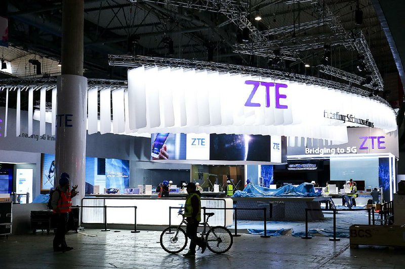 People mingle near the ZTE Corp. stand in Barcelona, Spain, in this 2017 photo. Shares of the Chinese technology company plunged 40 percent on Hong Kong’s stock exchange Wednesday, the first day the stock was traded since the U.S. government imposed heavy penalties on the company two months ago.
