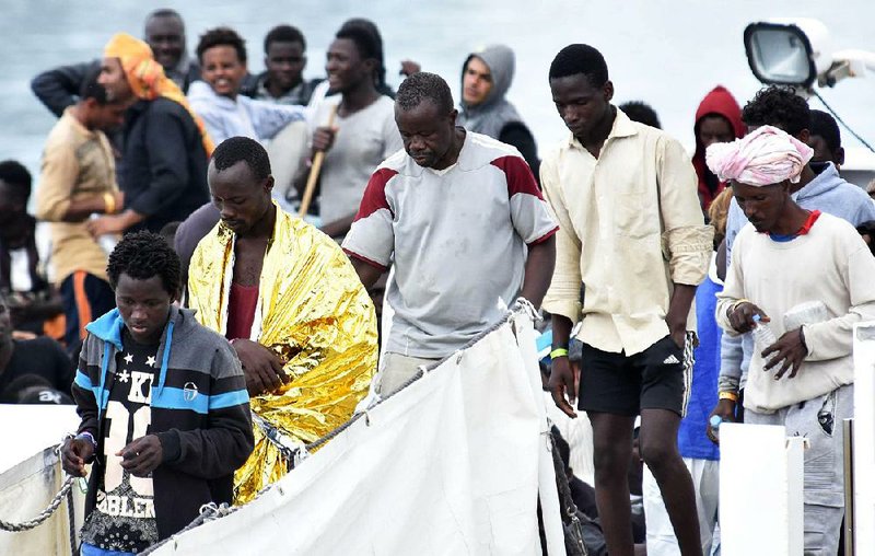 Migrants disembark from the Italian coast guard vessel Diciotti as it docks Wednesday at the Sicilian port of Catania. 