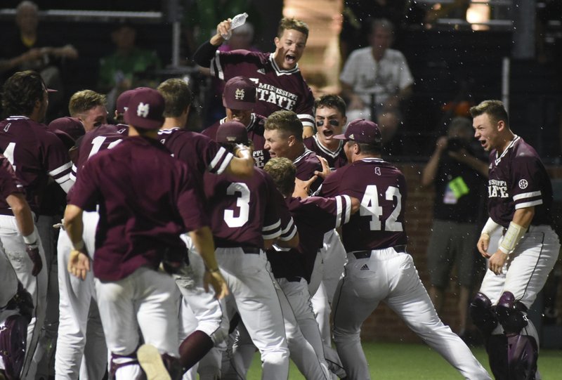 Mississippi State's Elijah MacNamee is swarmed at home after hitting a two-run home run in the ninth inning for a 10-8 win over Vanderbilt in an NCAA college baseball super regional game Friday, June 8, 2018, in Nashville, Tenn. (AP Photo/Mike Strasinger)