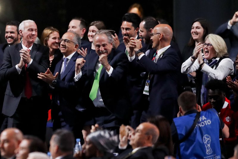 Delegates of Canada, Mexico and the United States celebrate after winning a joint bid to host the 2026 World Cup at the FIFA congress in Moscow, Russia, Wednesday, June 13, 2018. Standing on front row from left: Steve Reed, president of the Canadian Soccer Association, Carlos Cordeiro, U.S. soccer president and Decio de Maria, President of the Football Association of Mexico. (AP Photo/Pavel Golovkin)