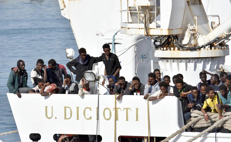Migrants wait to disembark from an Italian Coast Guard vessell "Diciotti" as it docks at the Sicilian port of Catania, southern Italy, Wednesday, June 13, 2018. The vessel docked in Catania with 932 migrants aboard in a sign that Italy under the populist 5-Star Movement and anti-migrant League is still accepting some migrants, but is forcing other countries to share the burden. (Orietta Scardino/ANSA via AP)