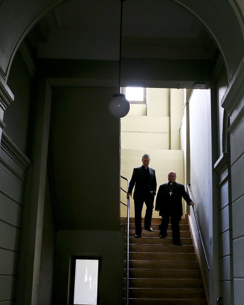 Archbishop Charles Scicluna, right, and Spanish Monsignor Jordi Bertomeuof, walk down a set of stairs prior a press conference at the Catholic University of Chile, in Santiago, Chile, Wednesday, June 13, 2018.  (AP Photo/Esteban Felix)