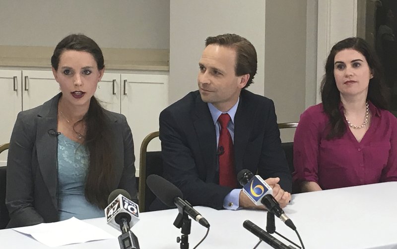 Rachael Denhollander, left, and Larissa Boyce, victims of imprisoned former sports doctor Larry Nassar, are joined by Michigan Lt. Gov. Brian Calley, center, at a news conference on Tuesday, June 12, 2018, in Lansing, Mich. Calley on Tuesday signed two bills inspired by the Nassar scandal, including one giving childhood sexual abuse victims more time to sue. (AP Photo/David Eggert)