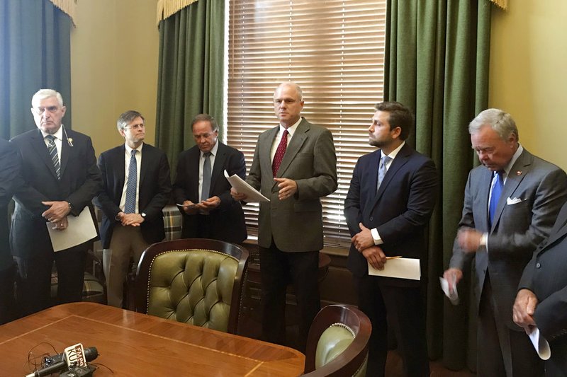 Arkansas state Sen. Jim Hendren, center, the incoming Senate president, talks to reporters at the state Capitol in Little Rock on Thursday, June 14, 2018, about proposed changes to ethics rules that will go before the chamber.